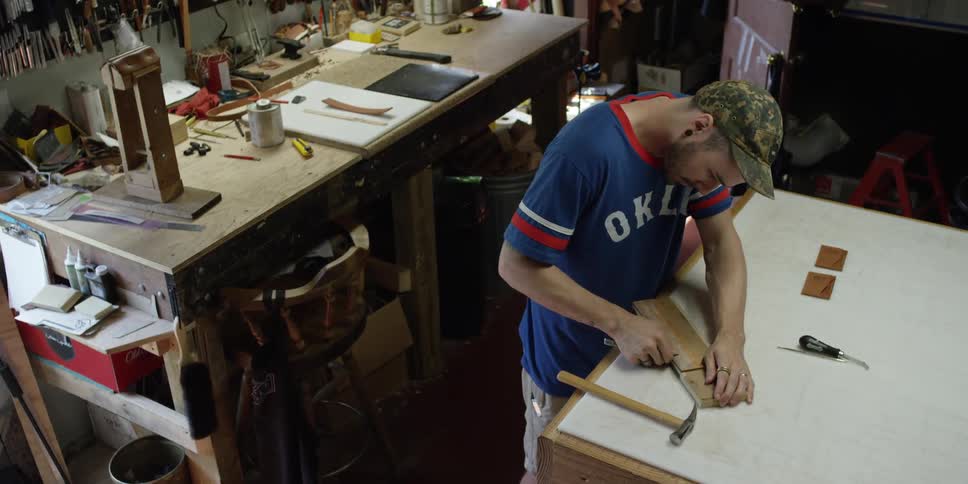 Man sharpening knife at a workbench