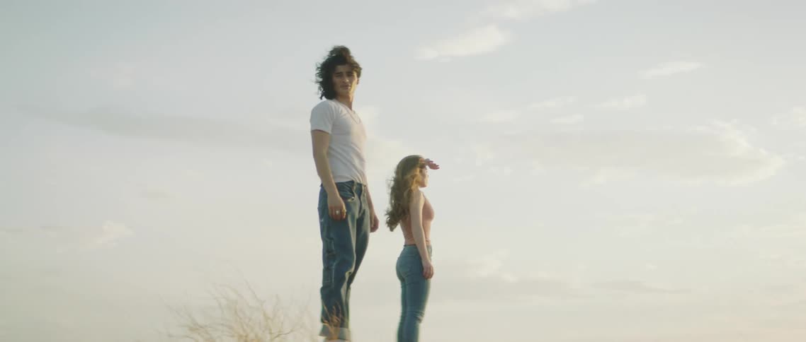 A couple walk on the hill and look around