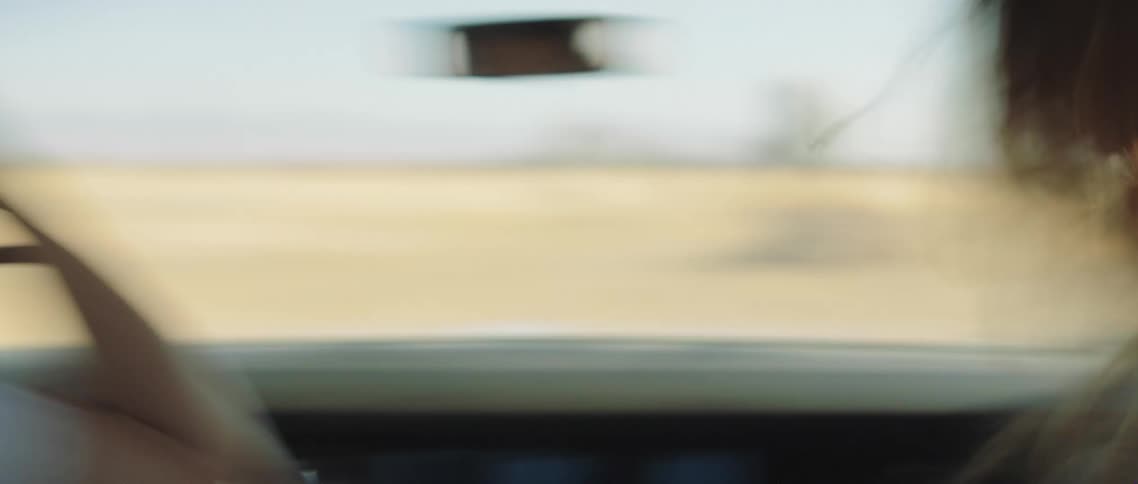 A woman running to a car and the car driving off