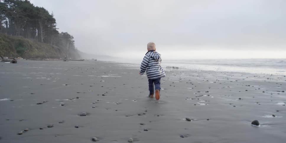 A boy runs along the beach