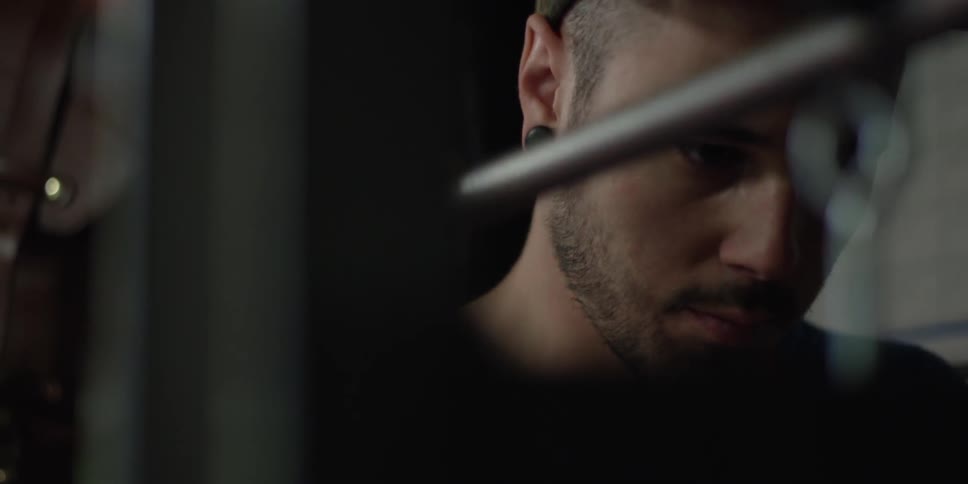 A bearded man pulls a metal lever