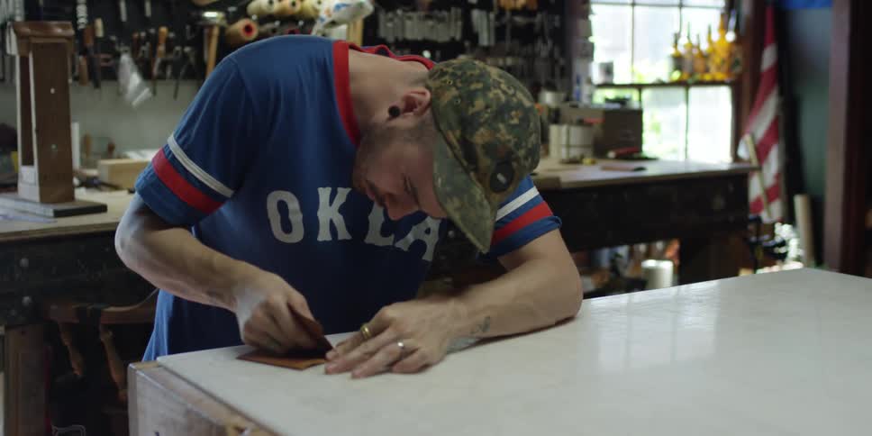 Man is hunched over a workbench