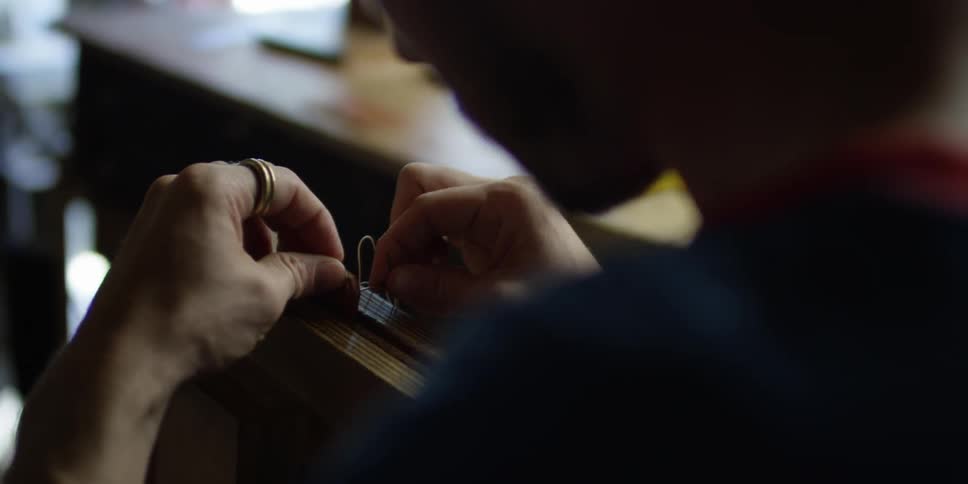 A man is working with a needle and thread