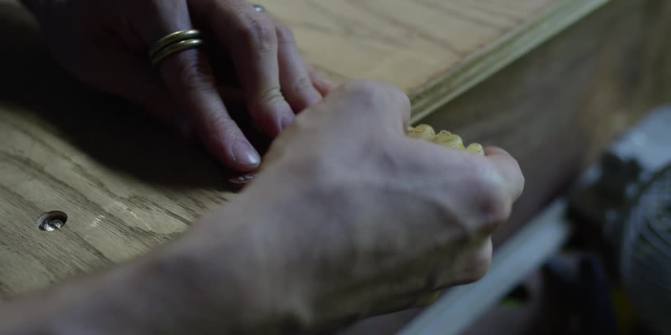 A man waxes a small leather wallet