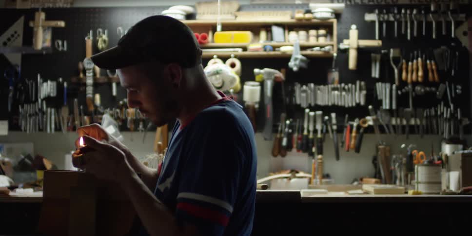 A man is using a lighter in a workshop
