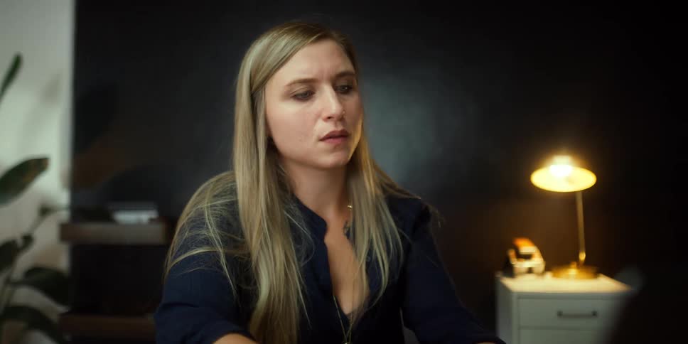 A young woman sits in an office and works on a computer