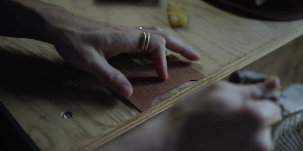 Leather is being polished on a wooden table