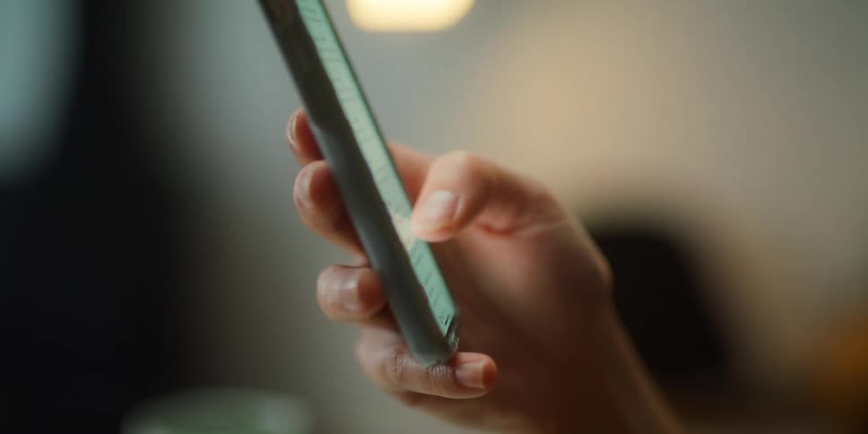 Close up of womans hand swiping down on smartphone screen