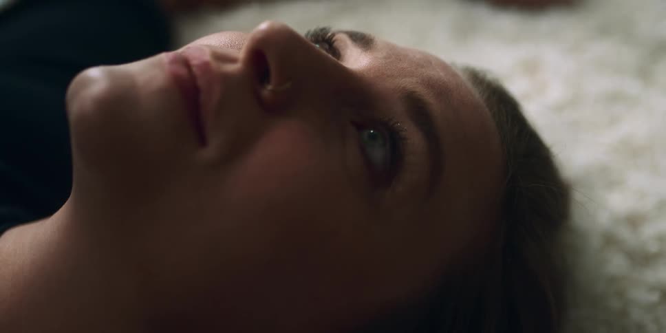 Young woman looking at the ceiling while resting over the white rug on the floor