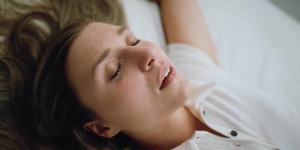 A woman in a room laying on a bed
