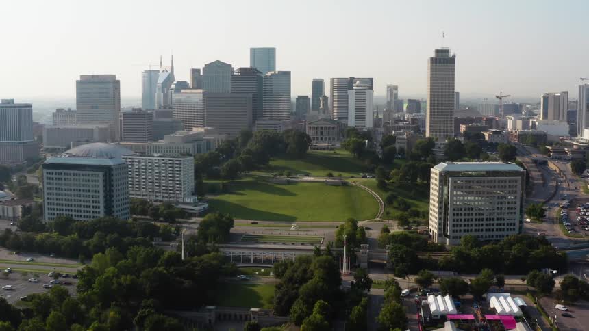 A city skyline with a highway buildings and skyscrapers with the sky and clouds in the background