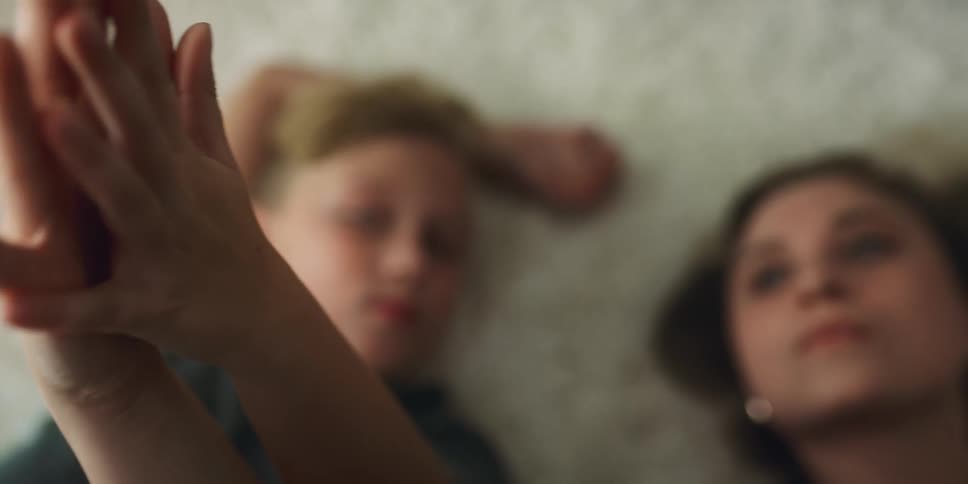 A woman and child hold hands on the carpet