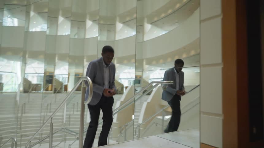 A man is walking up the stairs while using his phone