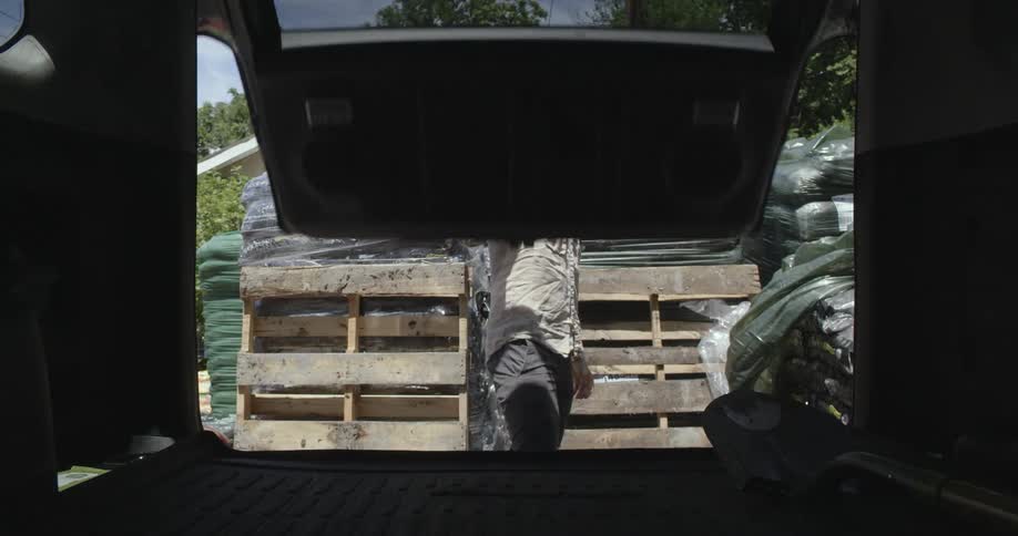A man opening the trunk of a van