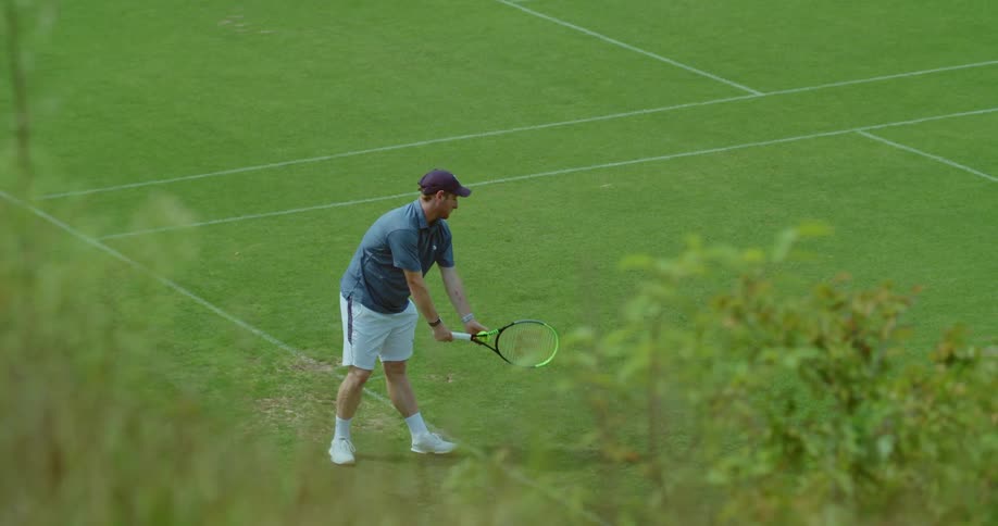 A man drives a tennis ball on the court