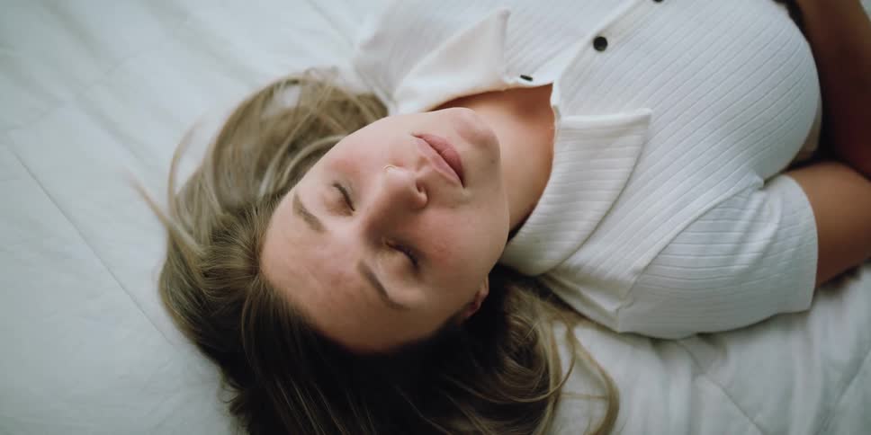 A woman in a room laying on a bed