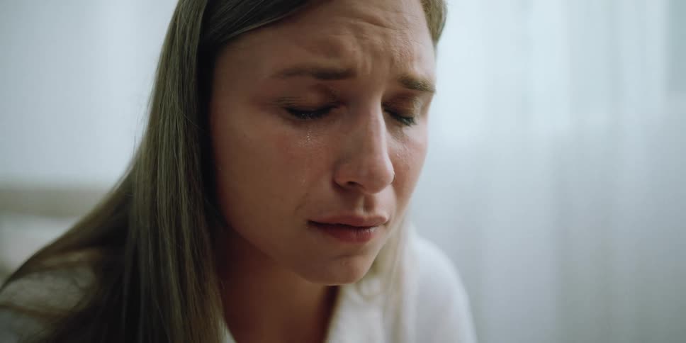 A woman sits at home and cries
