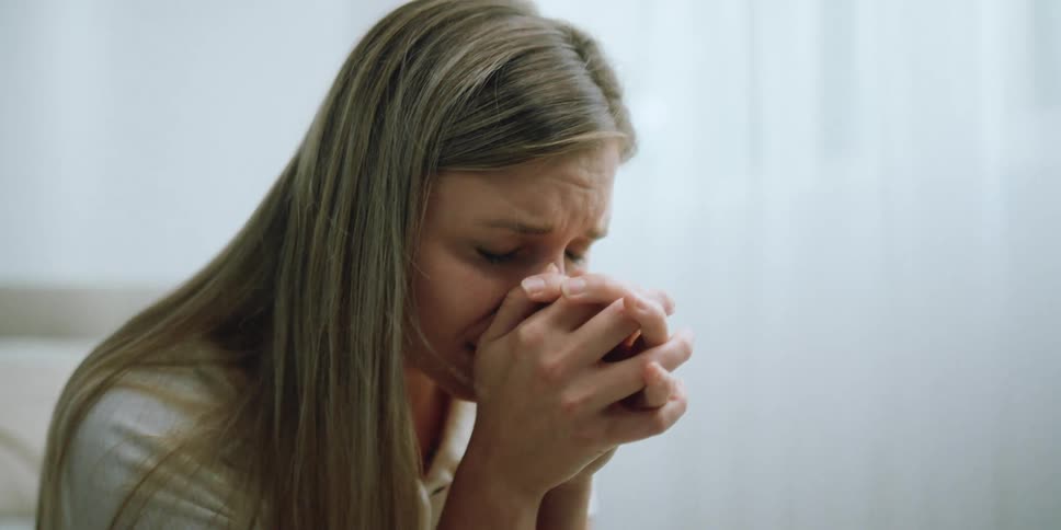 A woman is crying as she prays