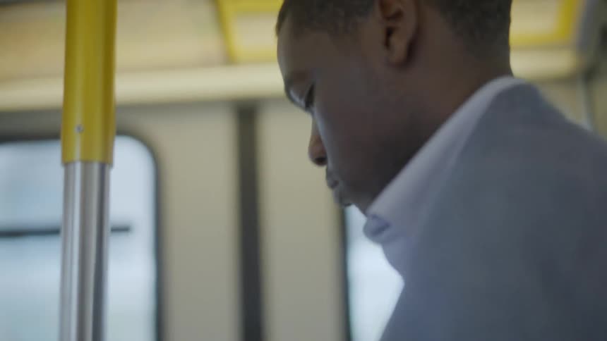 A man using a phone on public transport
