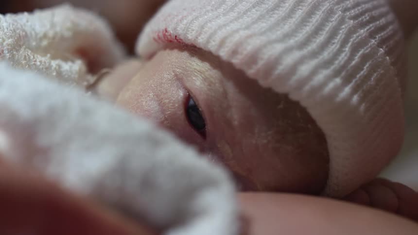 A mother holding a newborn baby on her chest