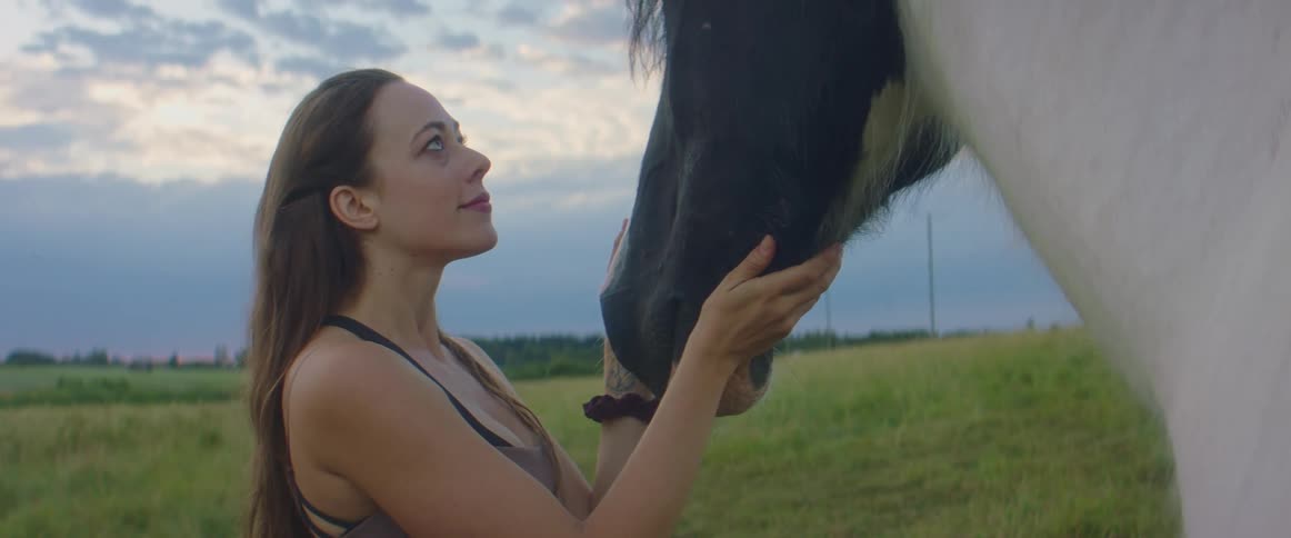 A woman caressing a horse