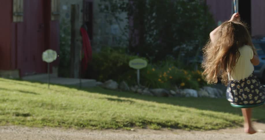 Two children play on a swing in together