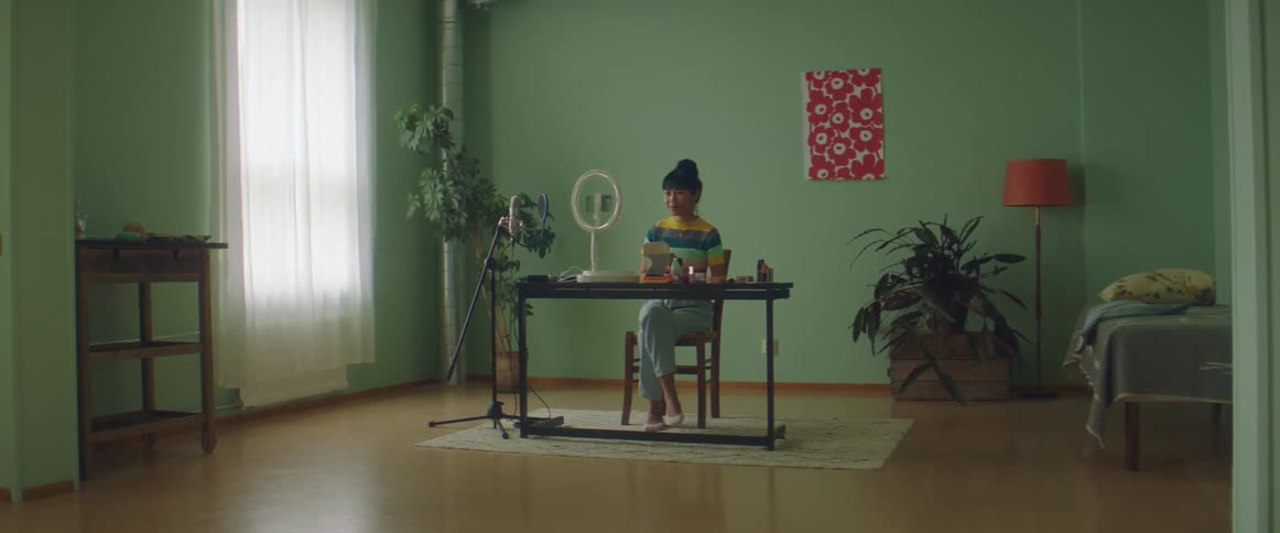 A woman is recording herself at the table