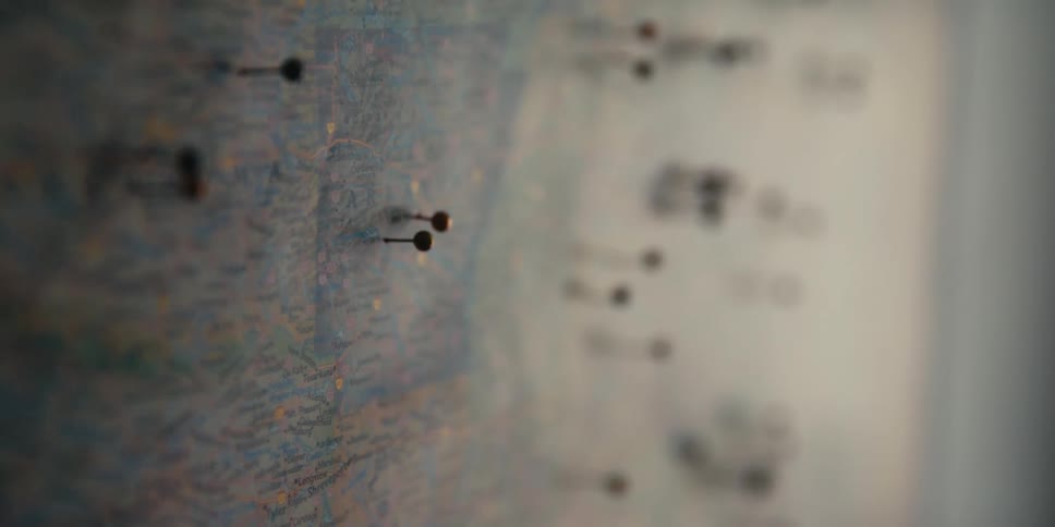 A room with a map on the wall with pins