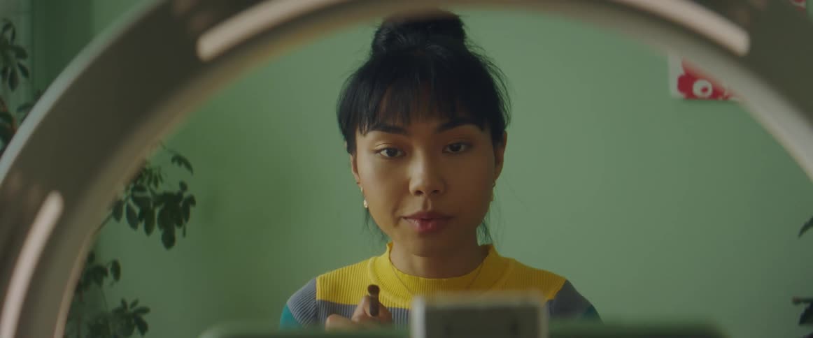A woman putting on makeup in a room