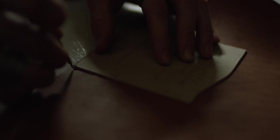 A man tracing a stencil on a piece of leather