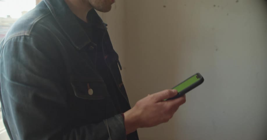 A man using a phone by a window