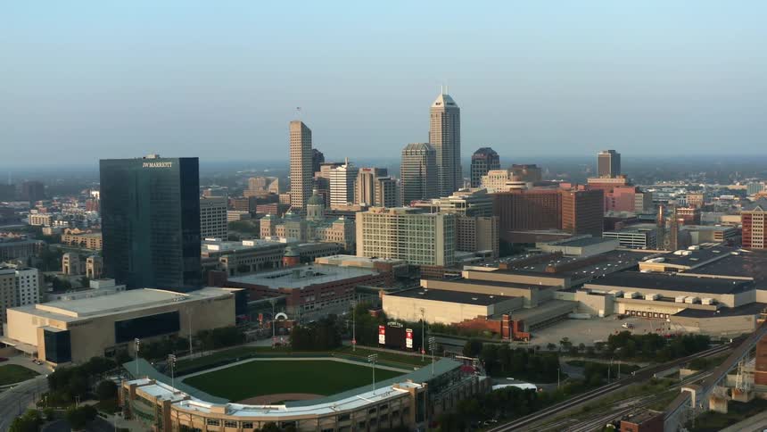 Aerial view of city buildings and ballpark at dawn