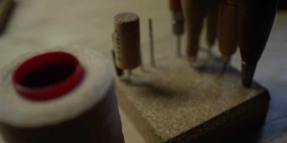 View of leather-working tools and twine on a table
