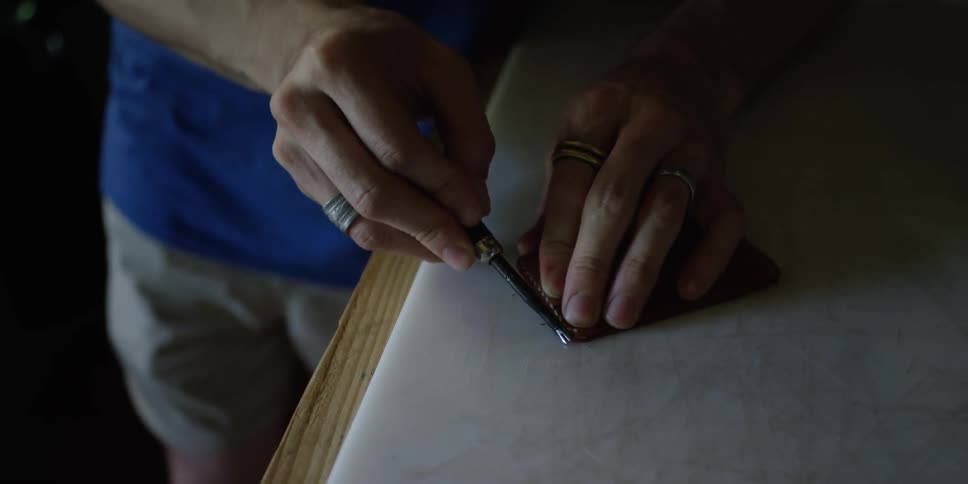 A man is using a tool on a bench