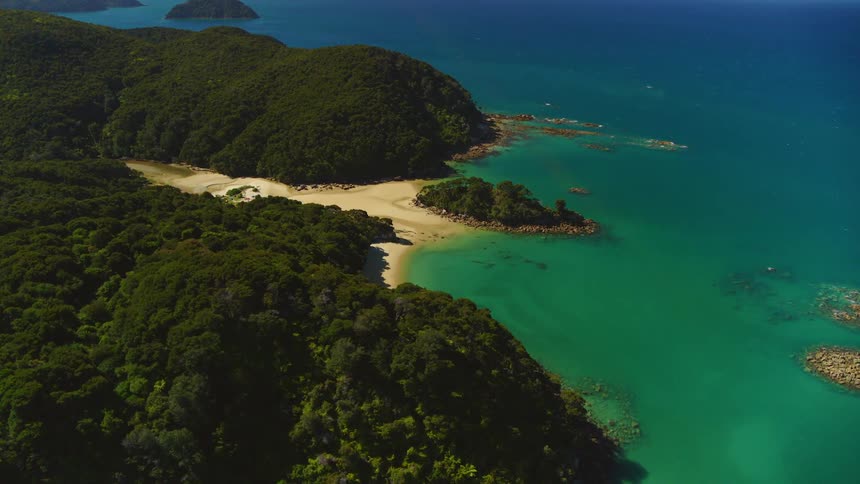 An aerial view of a tropical beach and coastline on a bright sunny day