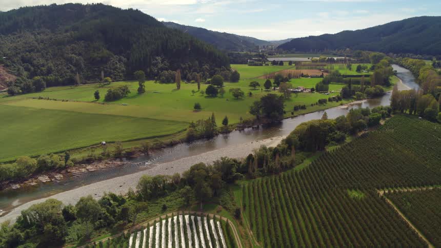 Aerial view of crops in the fields of a valley between the mountains
