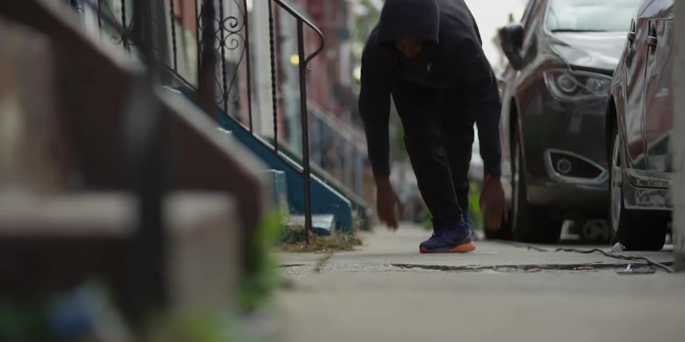 A man in black does push-ups and then gets up and walks away