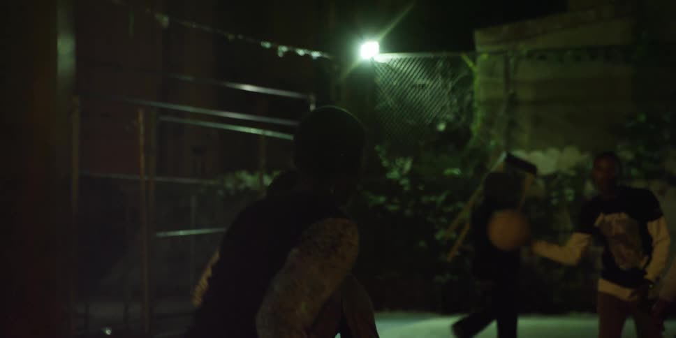 A group of people playing basketball at night