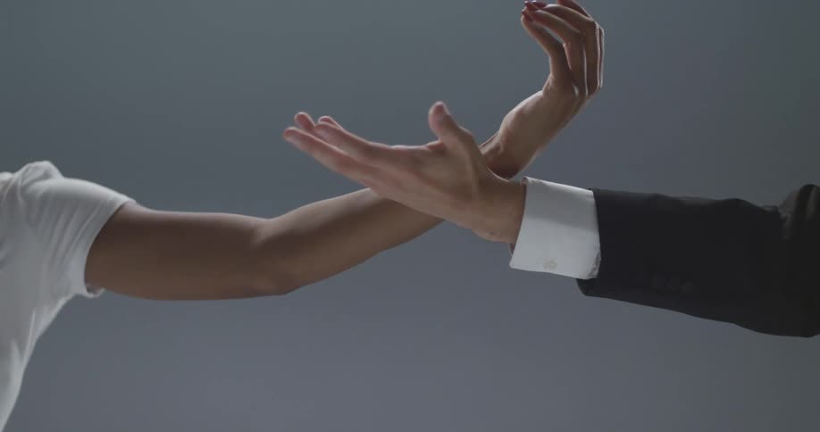 Two people doing shapes with their hands
