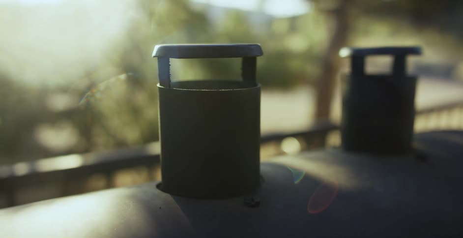 Smoke is coming out of a smoker that is on a deck