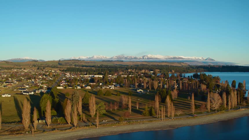A small town bordering a lake in countryside on a clear day