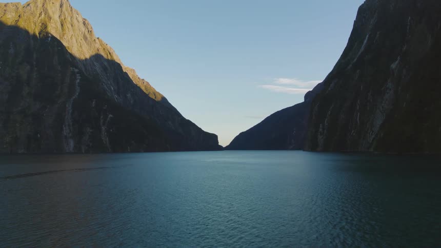 Lake between mountains with a few clouds in the sky
