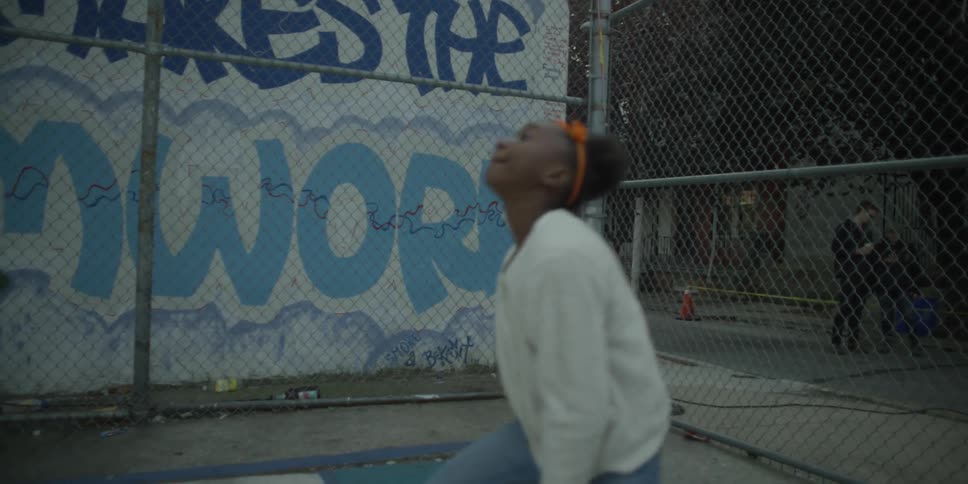 A girl dribbles a basketball in a park