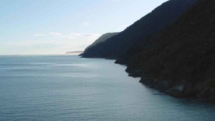 An aerial view of the ocean where it meets cliffs