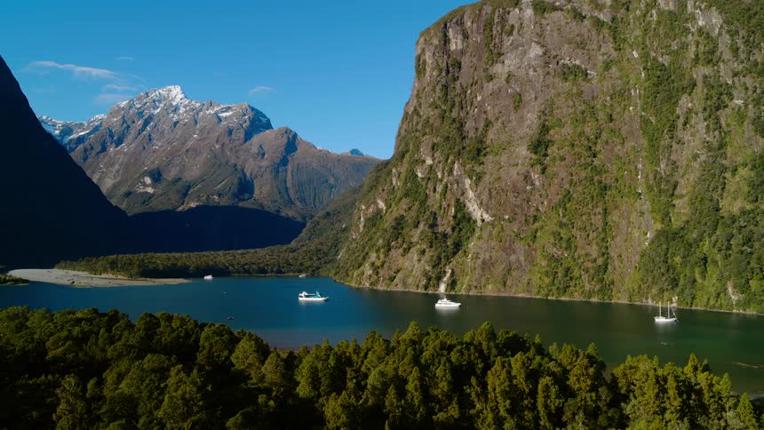 Lake with surrounding mountains and boats are in the water on a nice clear day
