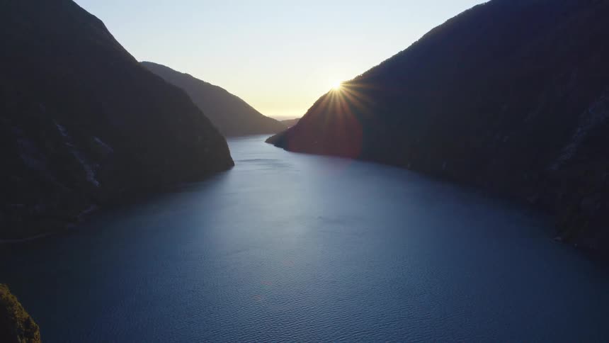 A river flowing between hills as the sun sets
