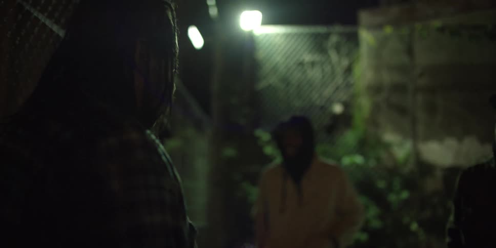 People stand outside at night talking