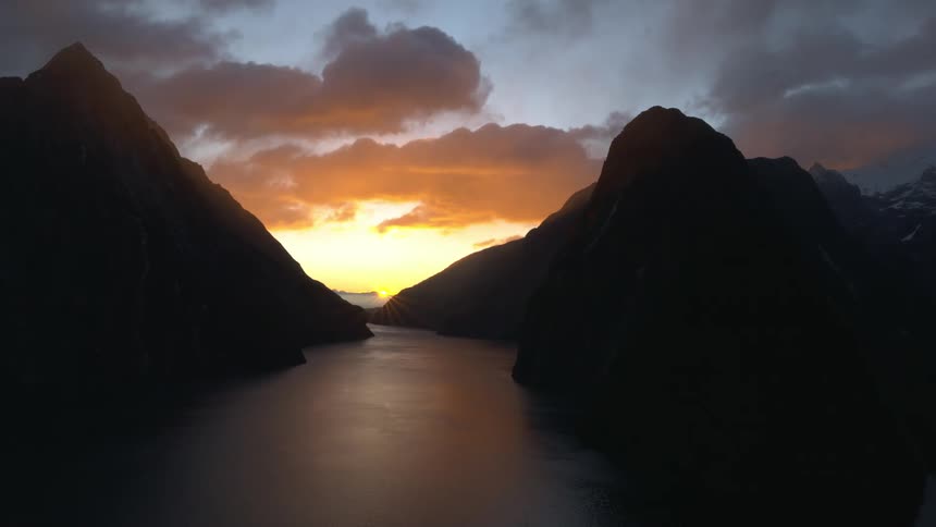 The sun rises between two mountain peaks