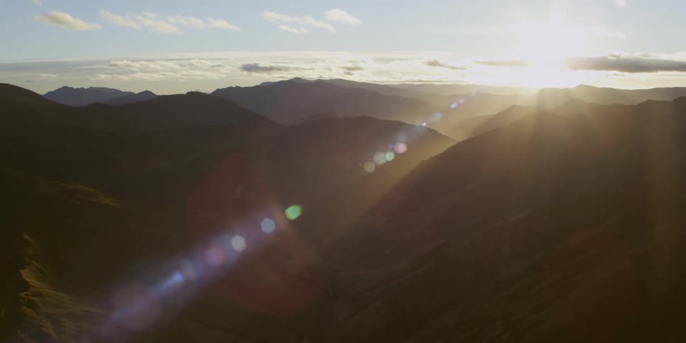 Aerial view of mountain ranges and valleys at sunset