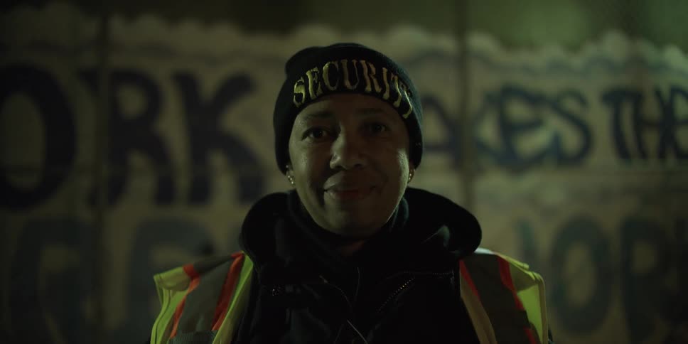 A woman is standing outside at night smiling